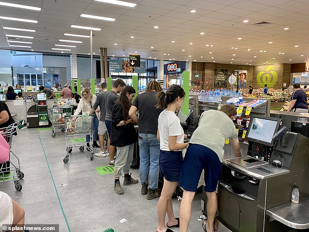 One shopper said his four-year-old daughter, who was sitting in the cart, was identified as an unscanned item, while a Woolworths cashier said technology sometimes identifies a customer's shoes as stolen (pictured, shoppers using Woolworths self-checkout)