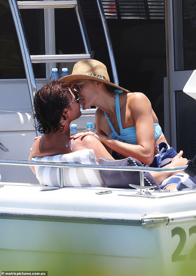 The couple could barely keep their hands off each other as they sat sunbathing on the deck of the ship.