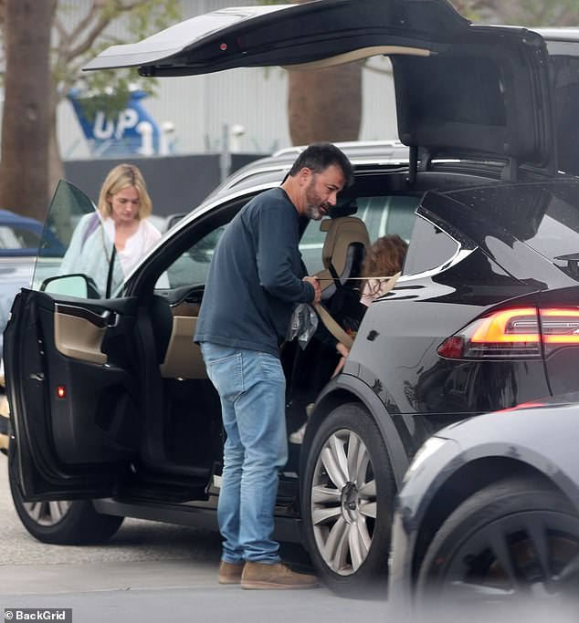 Packing up: Meanwhile, Kimmel loaded up the back of her family's vehicle in a long-sleeved navy top with denim jeans and brown suede shoes