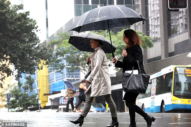 Wild weather, including heavy rain and flooding, is on the way across much of Australia.  In the photo, two women with umbrellas in the rain in Brisbane.