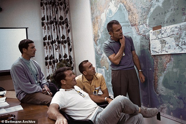 Members of the Apollo 7 crew (L-R Donn F. Eisele; Walter Schirra and Walter Cunningham) during a briefing with Deke Slayton (standing), director of Flight Crew Operations