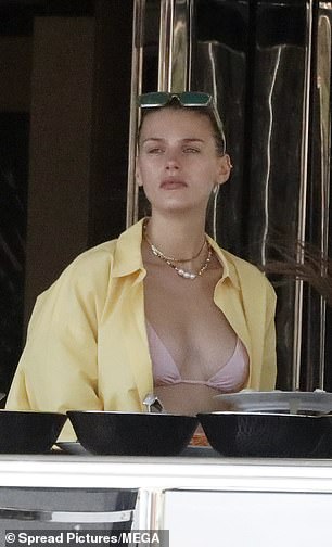 Looking lovely: Madison oozed beach chic in a skimpy blush bikini, which she layered with a pale yellow top and accessorized with gold jewelry