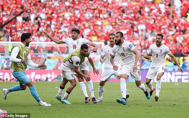 The Iranian soccer team celebrates after scoring their first World Cup goal against Wales