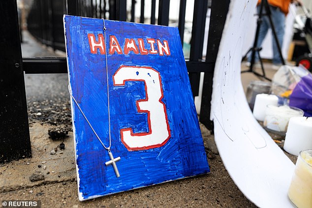 Items are placed by football fans during a vigil outside University of Cincinnati Medical Center