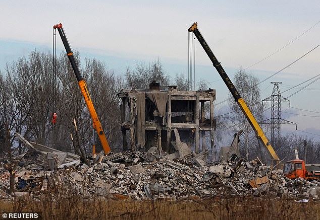 Workers remove debris of a destroyed building purported to be a vocational college used as temporary accommodation for Russian soldiers, dozens of whom were killed in a Ukrainian missile strike