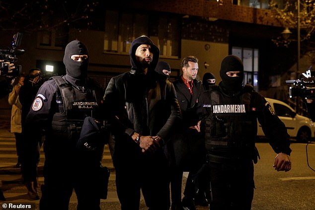 Pictured: Andrew Tate and Tristan Tate are escorted by police officers out of the Bucharest Directorate for Investigation of Organized Crime and Terrorism (DIICOT) headquarters after being detained for 24 hours, in Bucharest, Romania, on December 29, 2022.