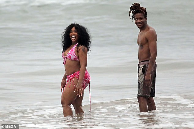 Good morning: The 33-year-old Grammy Award winner wowed in a low-cut pink and white bikini top with matching bottoms and a cover-up during her day at the beach