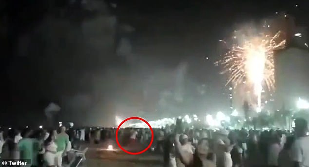 Police in Brazil are searching for a man (circled) who was seen on video running away after igniting a rocket that struck and killed Elisângela Tinem, 38, on Sunday.