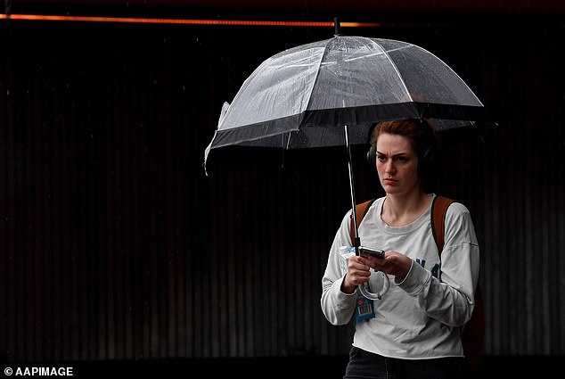 Victoria and New South Wales were hit by huge thunderstorms as a cold front moved in from the northwest.  In the image, a woman holding an umbrella.