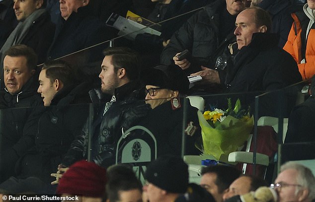 West Ham co-owner David Sullivan sits next to the empty seat with the flowers laid out.