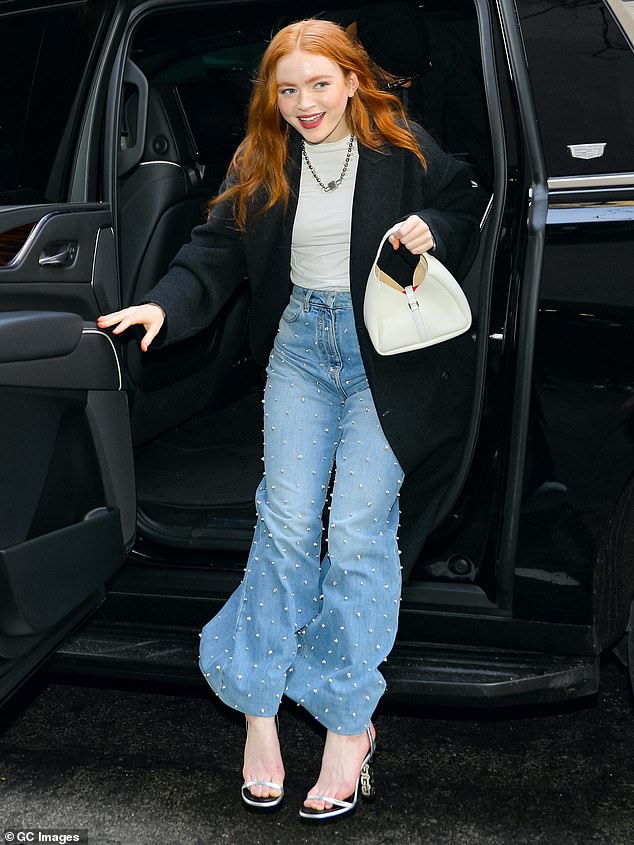 Boho-chic: The up-and-coming actress looked radiant and modern when she arrived at the NBC studios in Manhattan.  With her red hair loose in bright waves, the young actress rocked a boho-chic look that paired a long black pea coat with studded flared jeans.