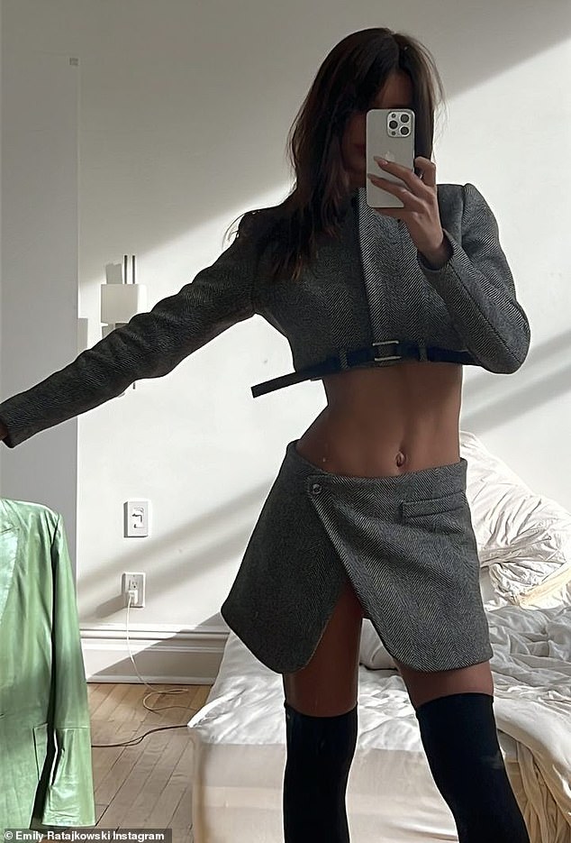 Fine figure: The bombshell wore a gray two-piece skirt and top set that showed off her entire stomach and miles of legs