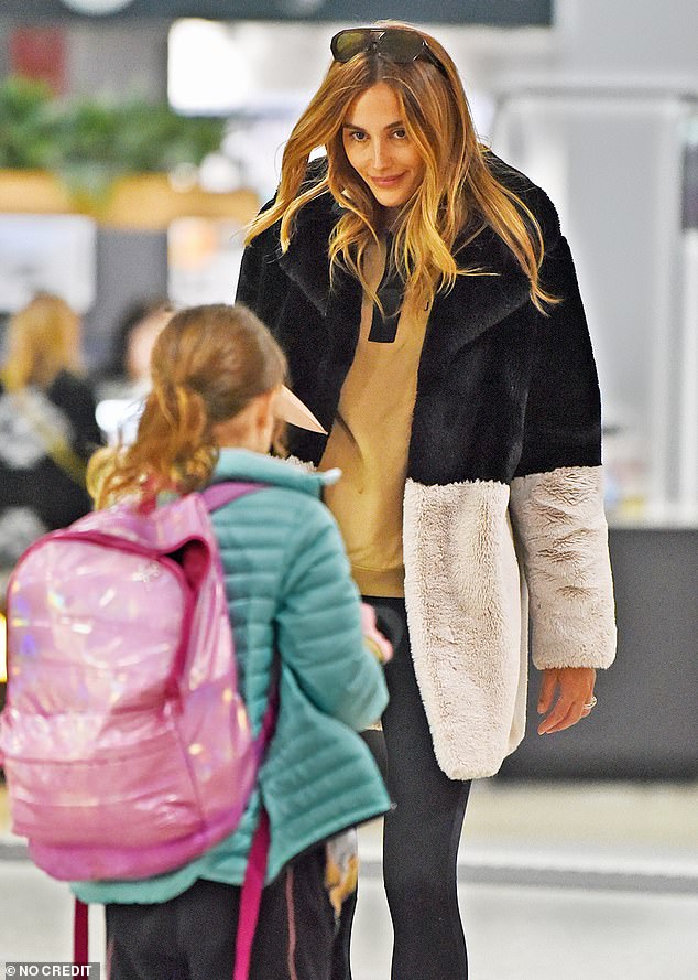 Bec and Chris seemed to be in high spirits as they walked through the terminal with their children.