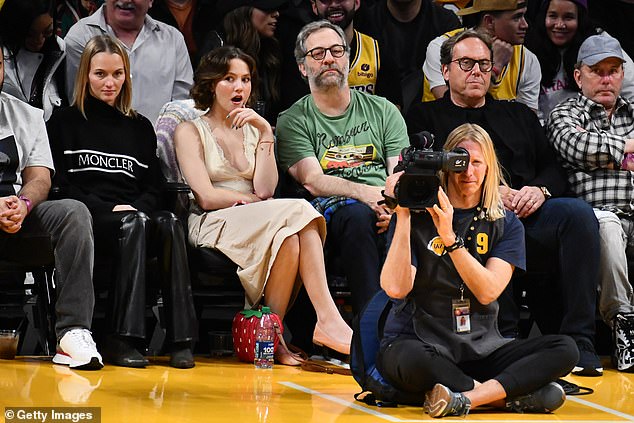 Game time!  In her first public appearance since the article ran, Maude, 25, sat next to the famed comedian, 55, as they joined other stars in the game.