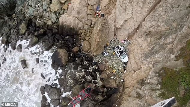 The white Tesla is seen at the bottom of the cliff in Devils Side on Monday after the accident.