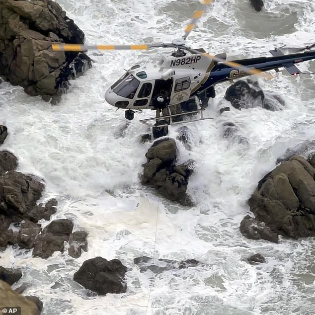 This image from video provided by the San Mateo County Sheriff's Office shows a rescue helicopter after a Tesla plunged off a cliff in Northern California.