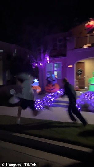 Members of the group are seen walking past children carrying bags of candy before one of the group members grabs him and runs down the street.