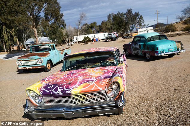 Old cars painted as sculptures in the desert town of Nipton, California