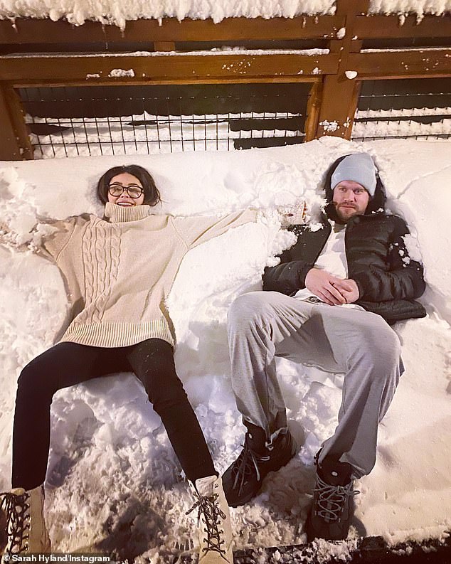 Icy fun: Sarah stretched out in the snow next to Glee actor Chord Overstreet, 33, outside the cabin