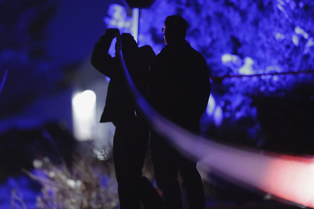 Law enforcement officers stand near the house.  Police said they did not detect any threats to the public.