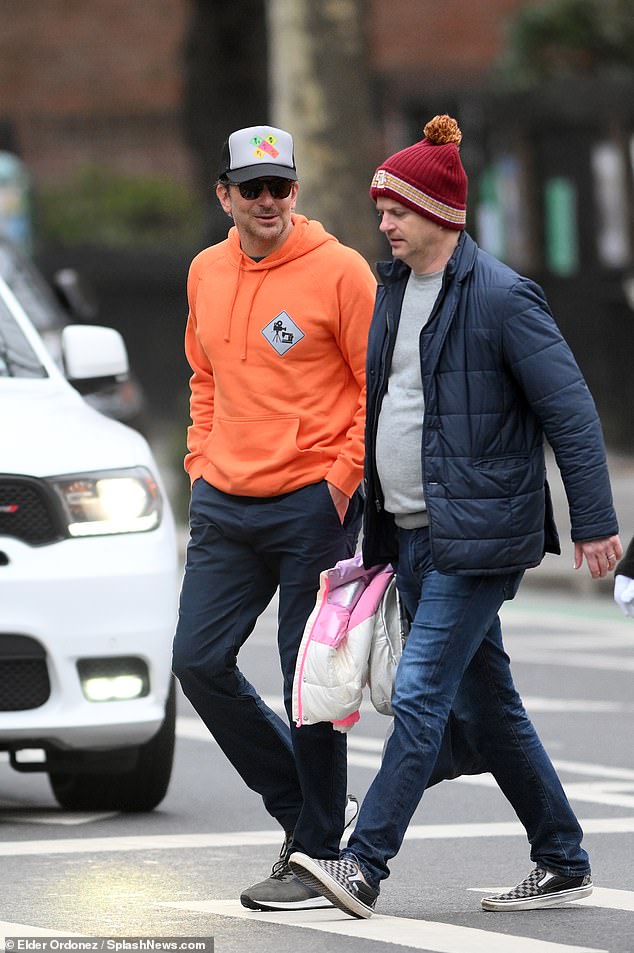 Walk and talk: Cooper was seen chatting with another friend at one point