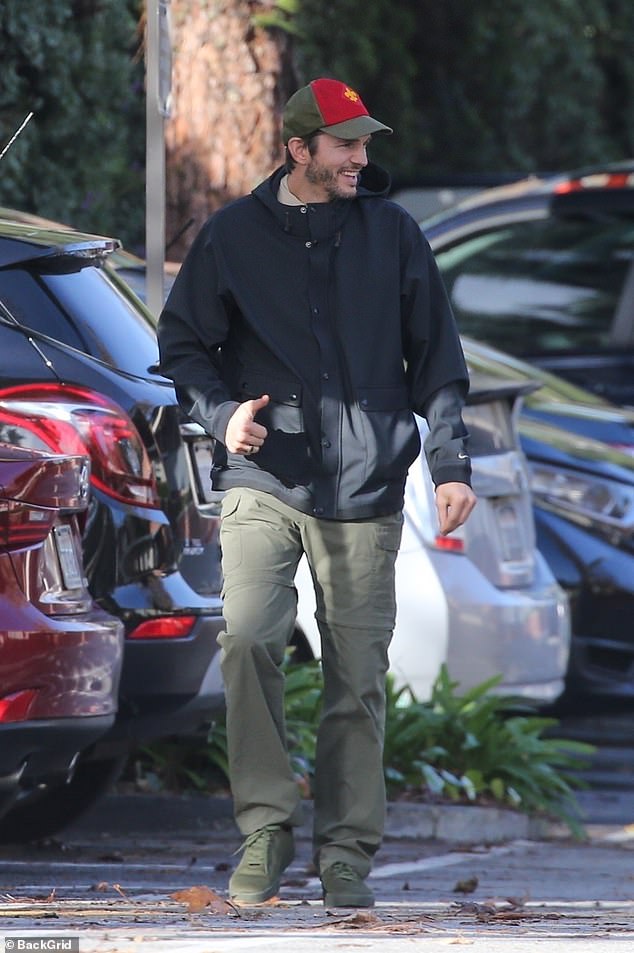 Ashton's look: Kutcher stepped out on a rare rainy day in Los Angeles in a brown T-shirt under a navy Nike hooded coat