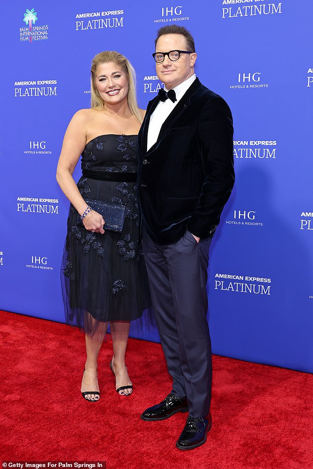 Smith donned a navy embellished off-the-shoulder black dress with a tulle overlay and black strapless sandal heels.