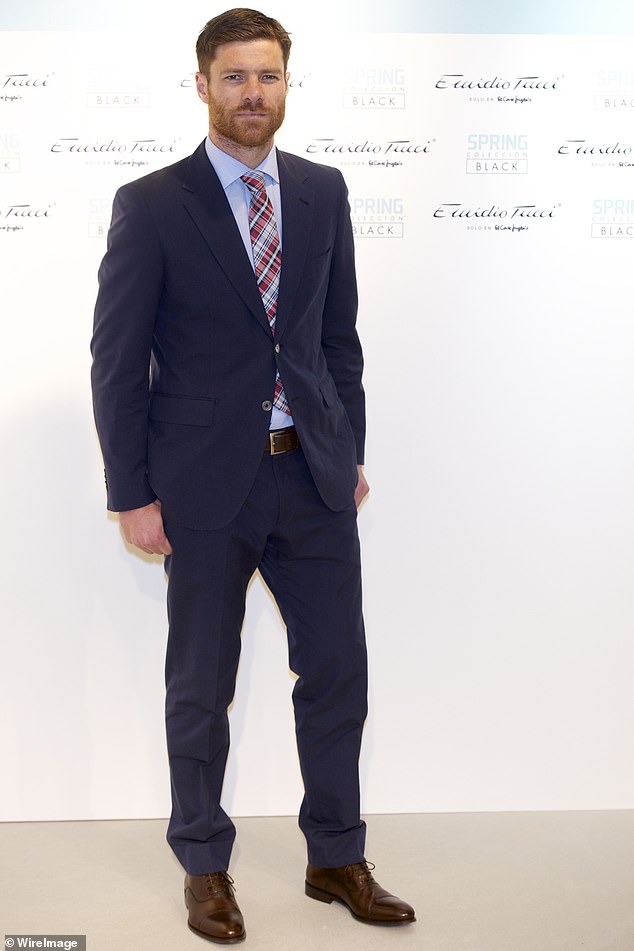 Former Spain international and Real Madrid midfielder Xavi Alonso was seen wearing a dark navy blue suit, dark brown shoes, a blue shirt and a tartan tie.