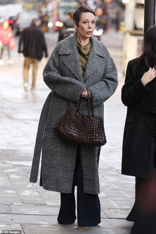 Polished: Looked effortlessly chic in her chic ensemble while adding a pop of color with a khaki green satin top