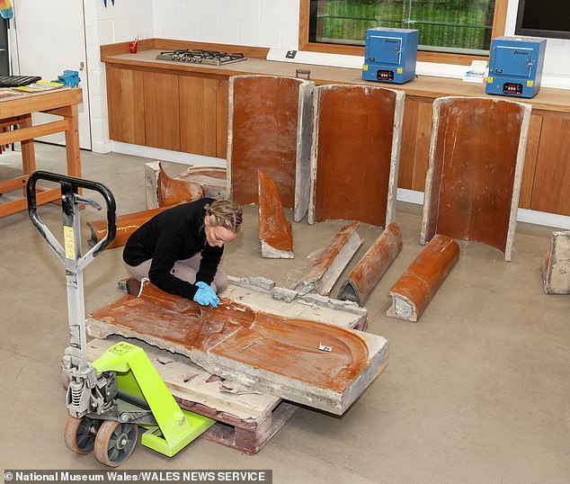 The pub's 107-year-old urinals are seen to be carefully stored before being rebuilt.