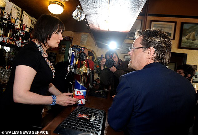 A waitress chats with a customer inside the Vulcan Hotel when it was still a thriving pub.