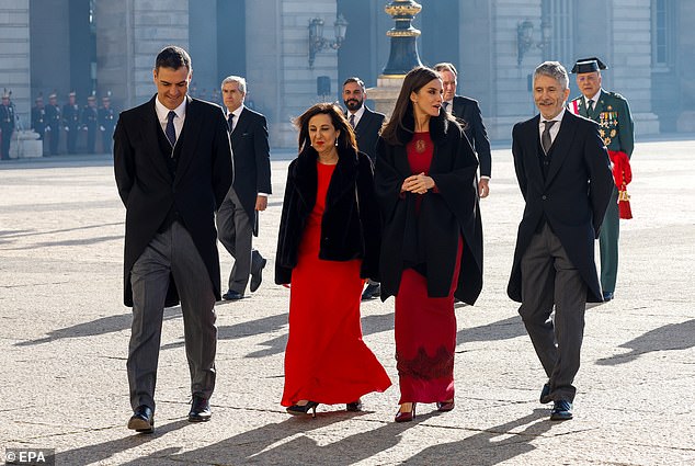 In a daring form-fitting gown by Spanish designer Felipe Varela, the Spanish royal, who enjoyed relaxing with her family away from the spotlight, looked well-rested at today's event to mark the Spanish holiday.  From left to right: in the photo with the President of the Government of Spain, Pedro Sánchez, the Minister of Defense, Margarita Robles and the Minister of the Interior, Fernando Grande Marlaska.