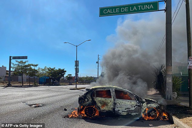 A burning car is seen in the street during an operation to arrest Joaquín's son "El Chapo" Guzmán, Ovidio Guzmán, in Culiacán, Sinaloa state, Mexico, on Thursday.