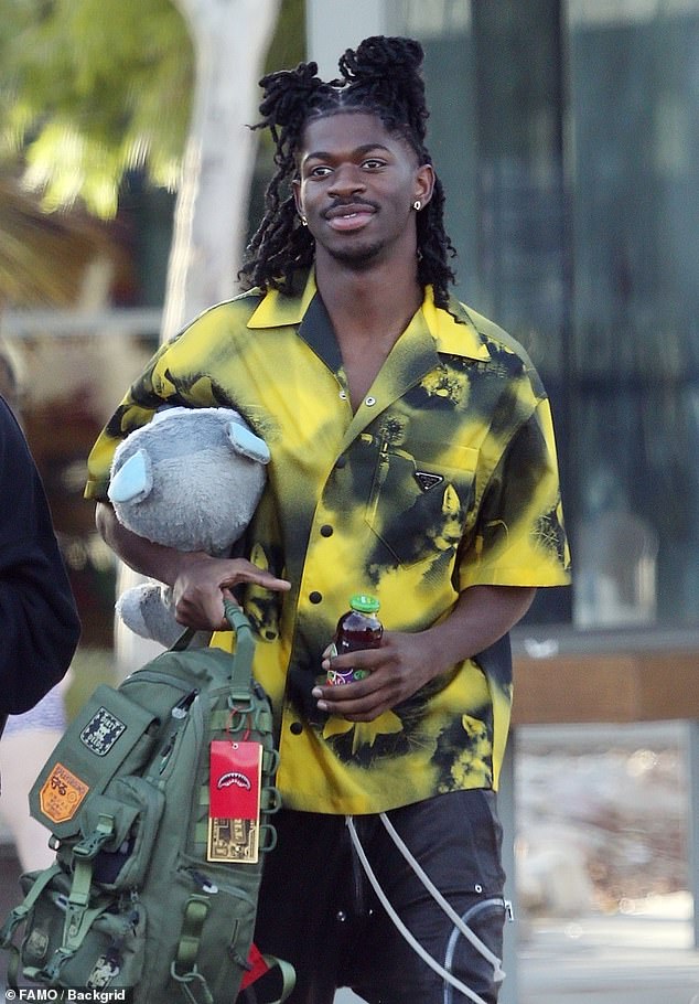 Looking as dapper as ever, the fashion icon donned a fresh yellow and black button-down shirt over baggy black cargo pants.