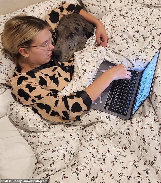 Multitasking: Millie appeared in a sweet image that showed her cuddling one of her beloved dogs while spending a little time on the computer