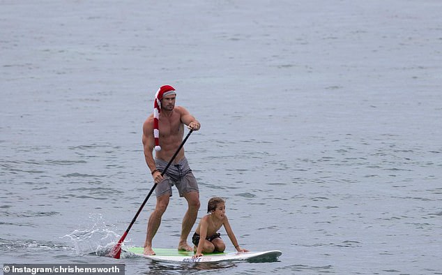 Chris took to the water on a paddle board while wearing a Santa hat.