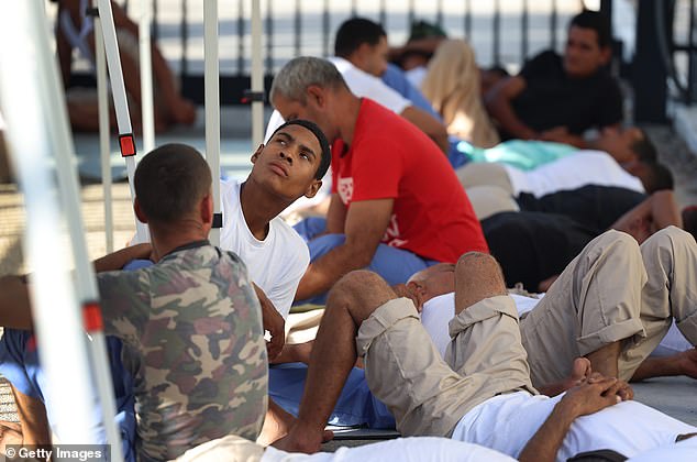 Pictured: Dozens of migrants waiting to be processed at the US Customs and Border Protection Station in Florida on Thursday.