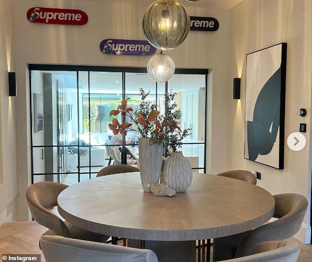 Elegant: In the open-plan living room, the couple also have a large round dining table with beige velvet seats beneath gray and silver lampshades.