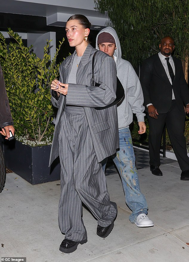 Casual: Justin went for a laid-back look, wearing a light gray hoodie and wide-leg jeans with a multi-color print.