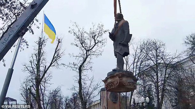 Many watched as the city's last remaining Soviet-era statue was dismantled, while the country's blue and yellow flag fluttered in the wind in the background.