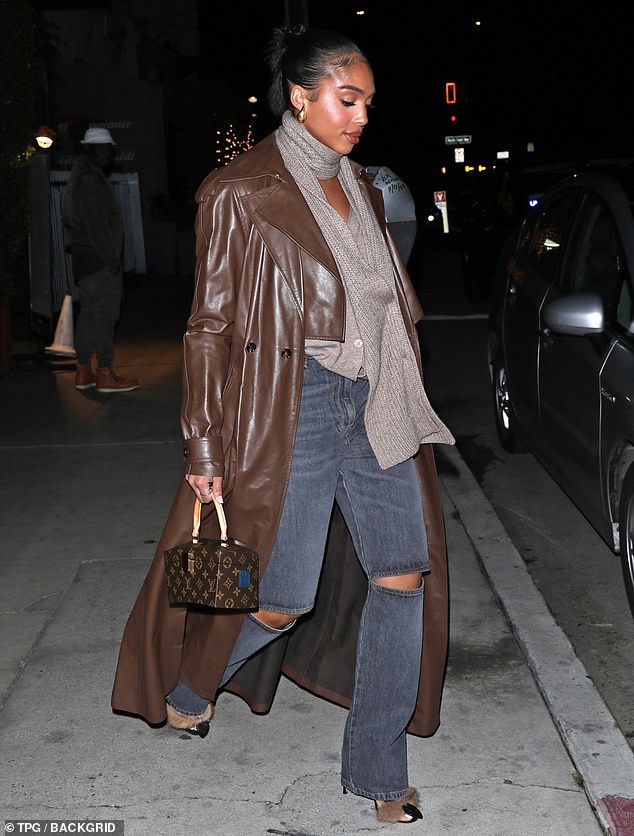 Stylish: The model, 25, rocked a gray top and long brown leather trench coat as she left the ritzy venue