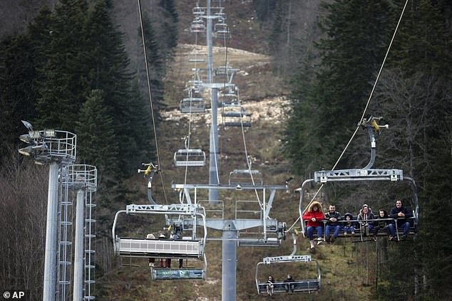 People ride the cable car on the snowless ski slope on the Bjelasnica mountain near Sarajevo, Bosnia