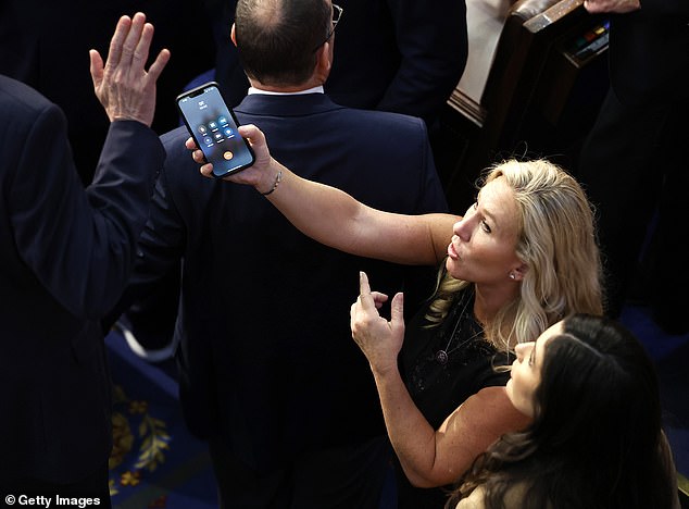 Marjorie Taylor Greene of Georgia could be seen trying to hand her phone to Rep. Matt Rosendale of Montana so he could answer Trump why he refused to vote for McCarthy.