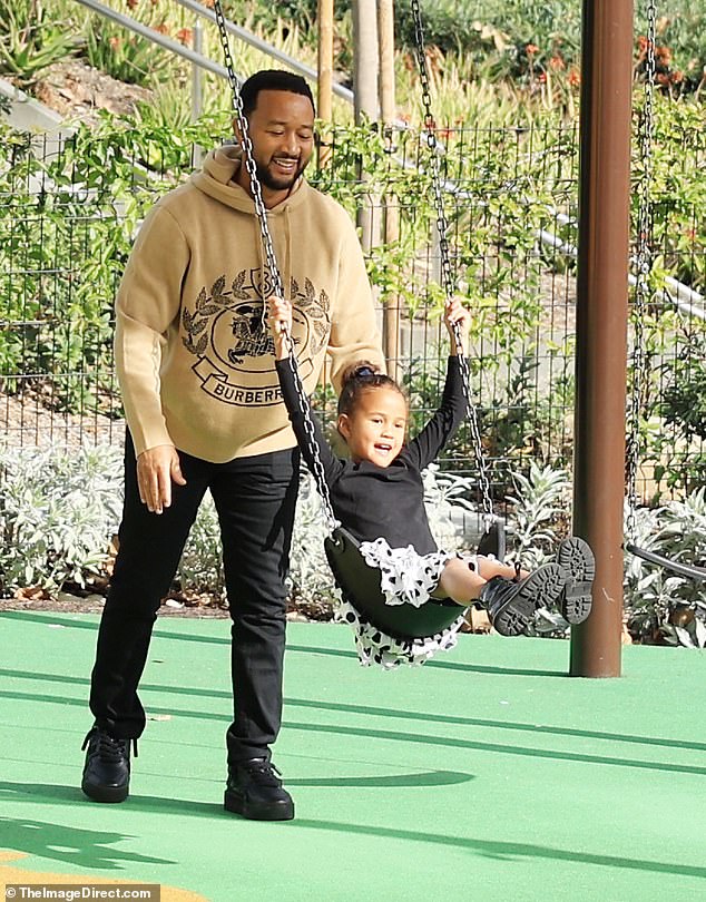 Fun moment: The trio headed to a playground where the Voice judge was seen pushing his little girl on a swing