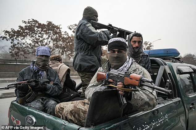 Taliban fighters patrol along a street during a rally by people to condemn the recent protest by Afghan women's rights activists, in Kabul on January 21, 2022.