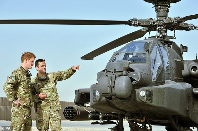 A member of his squadron (name not provided) shows Prince Harry the Apache flight line at Camp Bastion in Afghanistan, from where he operated during his tour of duty as co-pilot gunner.