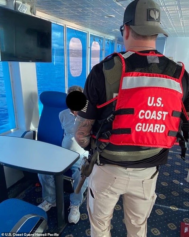 Jackson, on his boat in handcuffs after the Coast Guard seized the boat.