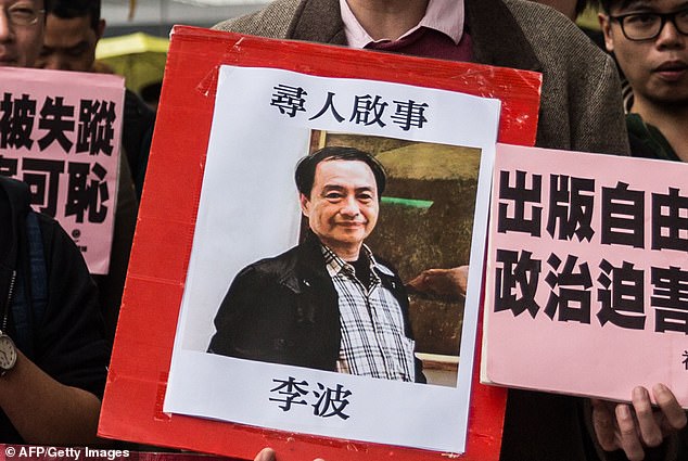 Wang claimed he was involved in the kidnapping of Hong Kong bookseller Lee Bo (depicted on a banner held up by a protester) in 2015 for selling works that were disliked by the Chinese Communist Party.