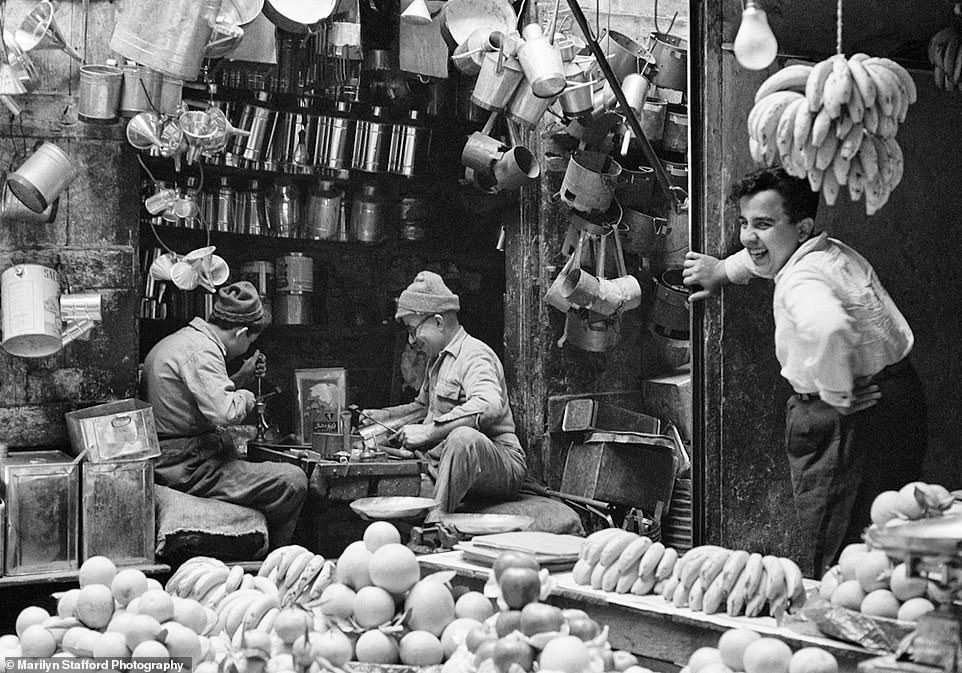 Marilyn Stafford captured a fruit vendor and a tinsmith conversing in a market in Tripoli, Lebanon, in 1960.