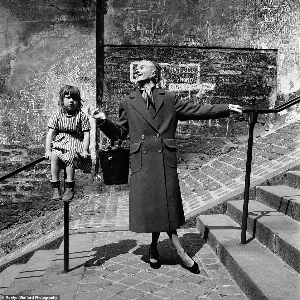 Marilyn Stafford captures a ready-to-wear model with a child in well-worn boots in Montmartre, Paris, circa 1955